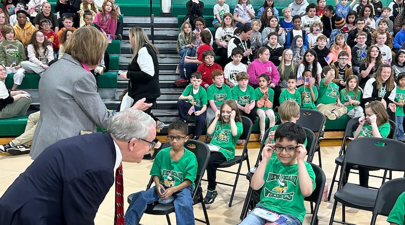 Gov. Mike DeWine and First Lady Fran check on some kindergarten and first-grade New Miami students who received free glasses Thursday afternoon as part of the Ohio Student Eye Exam program. RICK McCRABB/CONTRIBUTOR