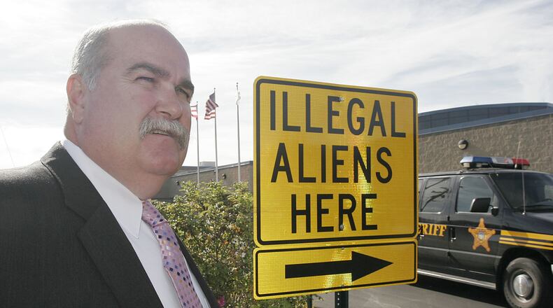 Butler County Sheriff Richard Jones stands next to a illegal aliens sign he had placed in the parking lot of the Butler County Sheriff’s Department, Thursday, Nov. 3, 2005 in Hamilton, Ohio. Jones says federal authorities aren’t doing enough to enforce immigration laws.