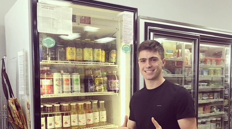 Luke West poses with drinks by WestWood Organics stocked on a store shelf. WestWood is aiming to open in Kettering later this year. CONTRIBUTED