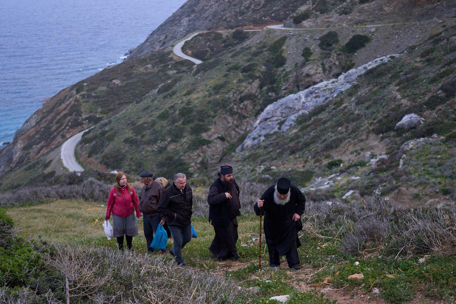 Orthodox Christian monk Father Spyridon of Amorgos, right, Father Antonis and other faithful leave the chapel of Panagia Evangelistria, after participating in Divine Liturgy in Amorgos island, Greece, on Monday, March 24, 2025. (AP Photo/Petros Giannakouris)