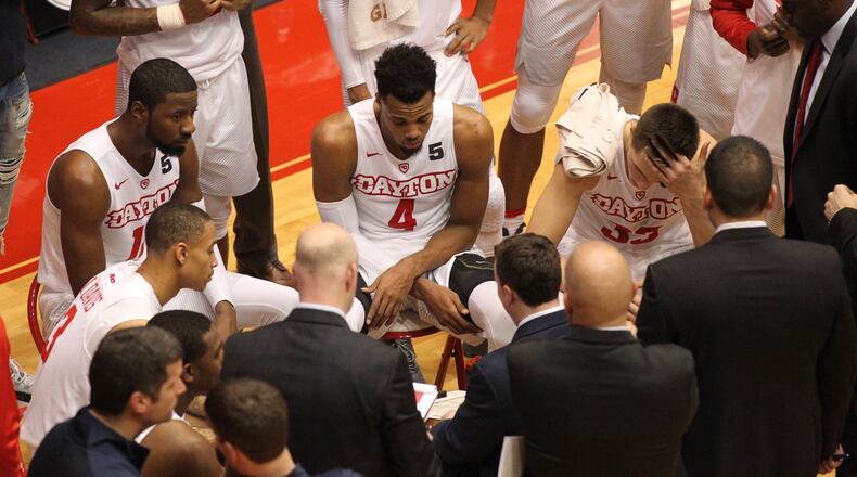 Dayton players huddle around coach Archie Miller during a game against Saint Joseph’s College on Tuesday, Dec. 6, 2016, at UD Arena. David Jablonski/Staff