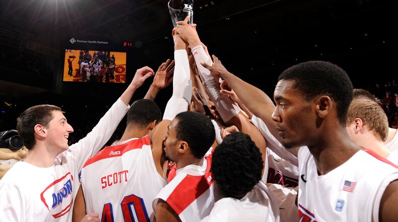 The Dayton Flyers hold up the Blackburn-Mcafferty trophy after defeating Xavier 70-59.