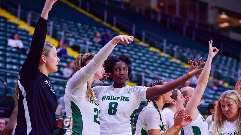 Wright State University's Grace Okih (8) holds up a 3-point sign with teammates during their game against Wilberforce on Nov. 12, 2025. JOSEPH R. CRAVEN / CONTRIBUTED PHOTO
