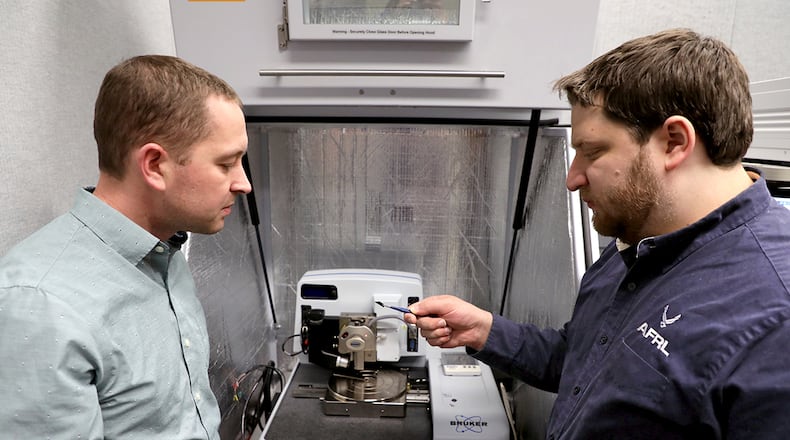 Dr. Nicholas Glavin (left), research scientist at the Air Force Research Laboratory, and David Moore, research scientist at UES Inc., load a sample into the analysis chamber of the the Bruker Atomic Force Microscope system. U.S. AIR FORCE PHOTO/SPENCER DEER
