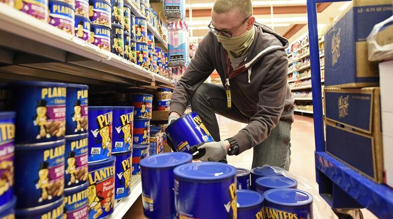U.S. Air Force Airman Kevin Reed, 88th Air Base Wing Communications Squadron, stocks shelves as a volunteer at the Wright-Patterson Air Force Base commissary on April 9.(U.S. Air Force photo/Ty Greenlees)