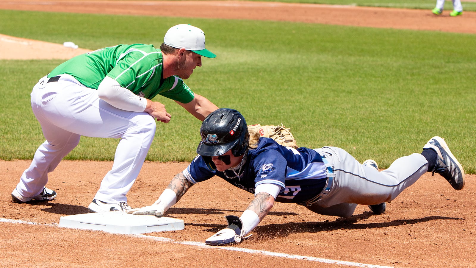 West Michigan's Max Clark dives safely back into first on  a pickoff attempt ahead of the tag by Dayton first baseman John Michael Faile. Jeff Gilbert/CONTRIBUTED