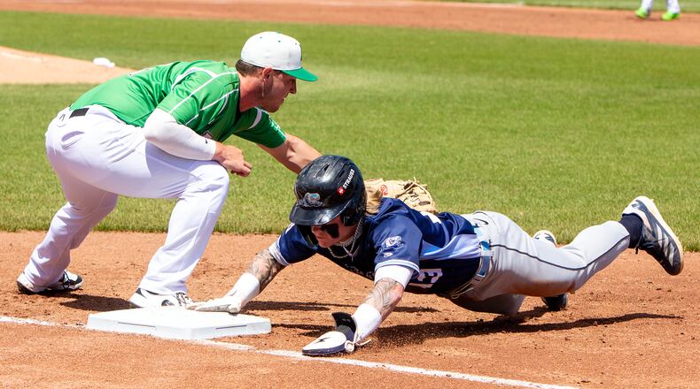 West Michigan's Max Clark dives safely back into first on a pickoff attempt ahead of the tag by Dayton first baseman John Michael Faile during their game on April 27, 2025 at Day Air Ball Park. JEFF GILBERT/CONTRIBUTED