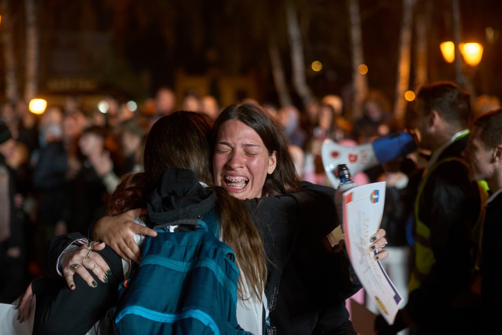 A student who walked across the country cries while hugging a friend as their group arrive at an anti-corruption protest in the southwestern town of Novi Pazar, Serbia, Friday, April 11, 2025. (AP Photo/Marko Drobnjakovic)