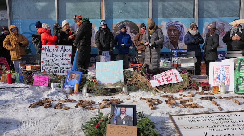 People gather near the scene where Alex Pretti was fatally shot by a U.S. Border Patrol officer yesterday, in Minneapolis, Sunday, Jan. 25, 2026. (AP Photo/Adam Gray)