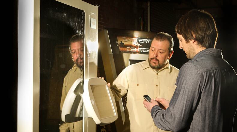 Patrick McDonald, president (left) and Jeff Thibodeau, vice president of operations, test a vending machine to dispense items using twitter, a technology new to the USA. Innovative Vending Solutions of Miamisburg creates vending machines that can dispense almost any product -- from tools to office products to novelty items -- almost any place for almost anyone, and says it is growing an increasingly international business. JIM WITMER / STAFF