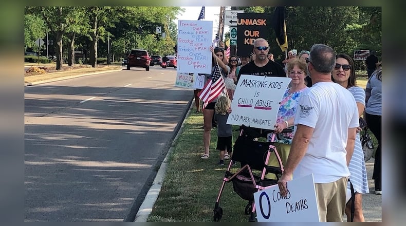 Protesters held signs against a mask mandate for Kettering students before Tuesday evening's school board meeting. Superintendent Scott Inskeep was expected to propose face masks for all students amid increasing COVID-19 cases and quarantines in the district, which started school Aug. 12 with masks optional. Nick Blizzard/Staff