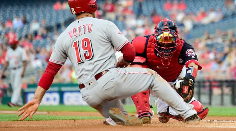 WASHINGTON, DC - AUGUST 12: Joey Votto #19 of the Cincinnati Reds is tagged out at home plate by Kurt Suzuki #28 of the Washington Nationals in the first inning at Nationals Park on August 12, 2019 in Washington, DC. (Photo by Patrick McDermott/Getty Images)