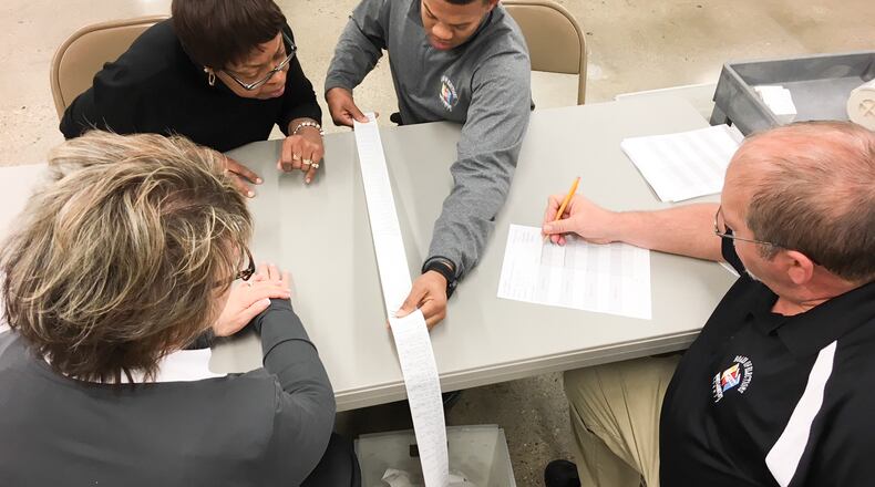 Workers at the Montgomery County Board of Elections tally up the votes from a machine printout during a recount of a close Nov. 6 race. Due to aging equipment, some of the printouts are unreadable, slowing the process. DARIN POPE / STAFF