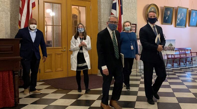 Lt. Gov. Jon Husted, Ohio Department of Health Dr. Amy Acton and Ohio Gov. Mike DeWine walk to their daily press conference. Laura Bischoff/Staff