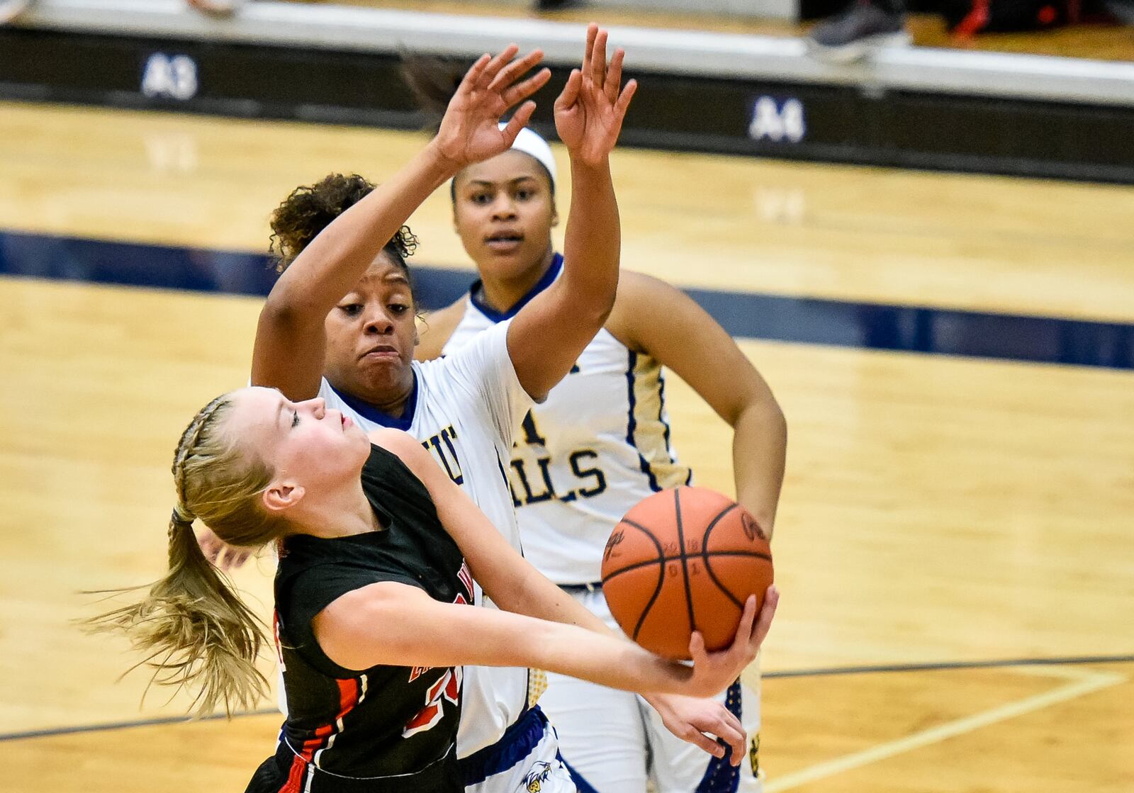 Lakota West's Ally Haar tries to scoop a shot toward the basket as Walnut Hills' Kennedi Myles attempts to make a block Wednesday night during a Division I regional semifinal at Fairmont’s Trent Arena. NICK GRAHAM/STAFF