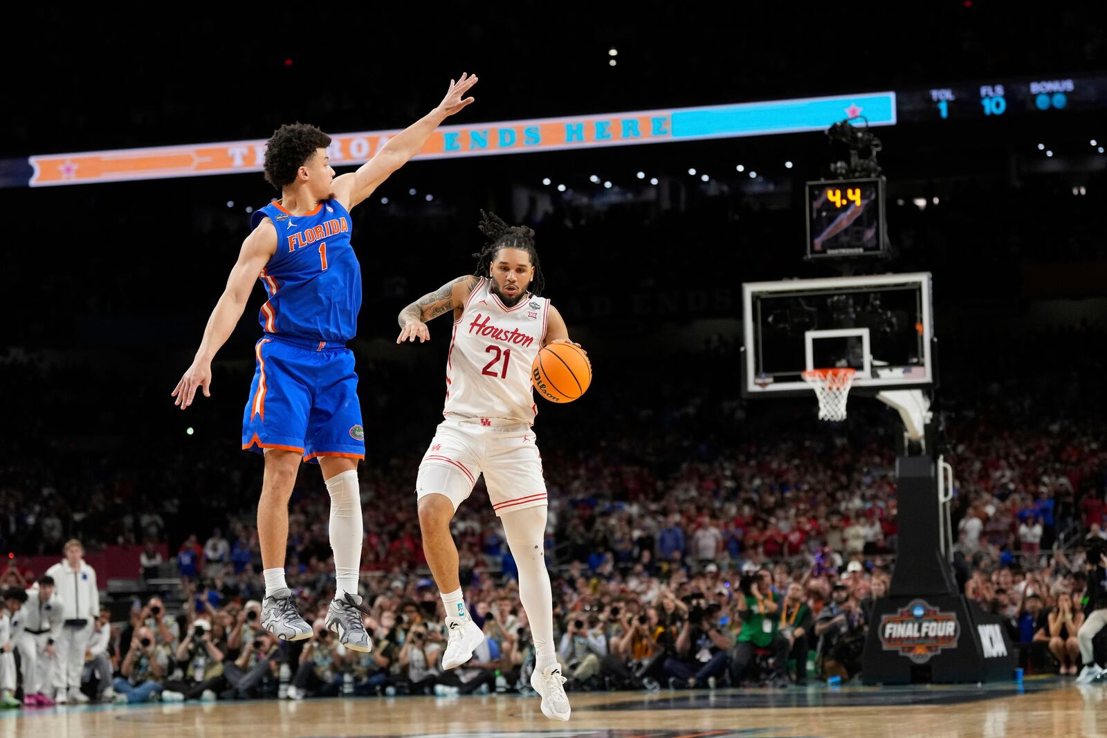 Florida's Walter Clayton Jr. (1) jumps to knock the ball from Houston's Emanuel Sharp (21) during the second half in the national championship at the Final Four of the NCAA college basketball tournament, Monday, April 7, 2025, in San Antonio. (AP Photo/Eric Gay)