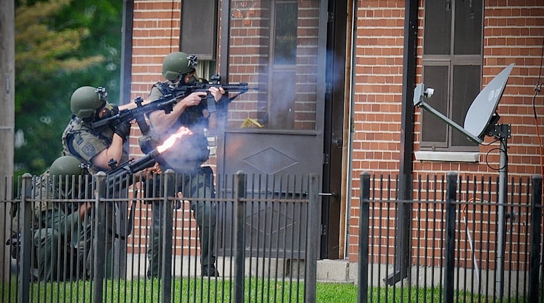 The Dayton SWAT team fires tear gas into an apartment May 18, 2022, after a man shot another man and then went back inside an apartment in the 1700 block of West Stewart Street. The victim, identified Tuesday, May 24, as 29-year-old Myquan R. Taylor, later died of his injuries. MARSHALL GORBY\STAFF