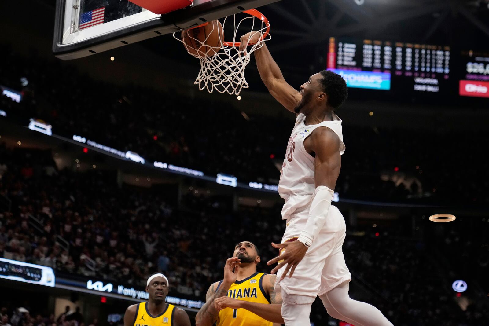 Cleveland Cavaliers guard Donovan Mitchell, top, dunks in front of Indiana Pacers forward Pascal Siakam, left, and forward Obi Toppin (1) in the second half during Game 1 in the Eastern Conference semifinals of the NBA basketball playoffs Sunday, May 4, 2025, in Cleveland. (AP Photo/Sue Ogrocki)