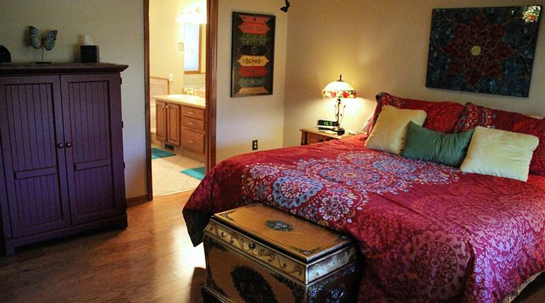 The main-floor bedroom suite is updated with hardwood flooring. Oak casings frame the double window and a designer paddle fan centers the ceiling.