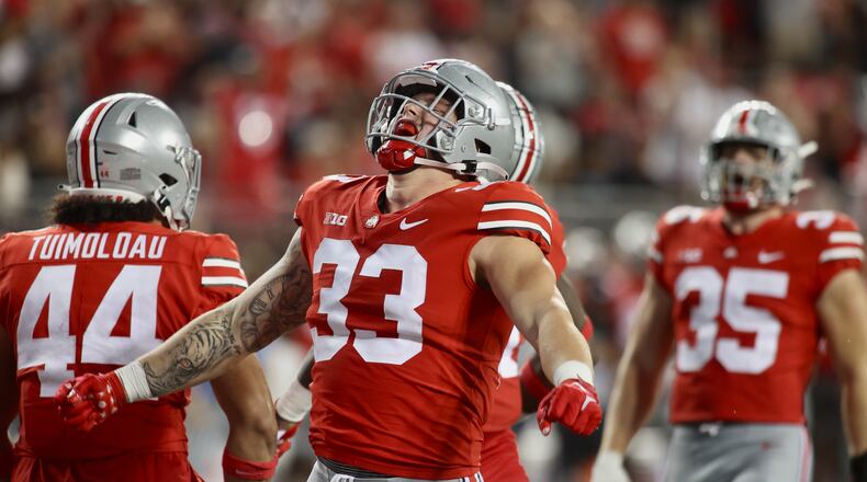 Ohio State's Jack Sawyer celebrates after Michael Hall Jr. sacked Notre Dame's Tyler Buchner late in the fourth quarter on Saturday, Sept. 3, 2022, at Ohio Stadium in Columbus. David Jablonski/Staff
