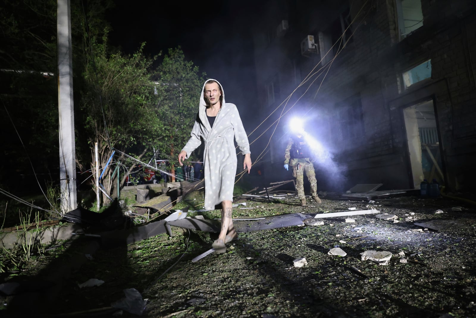 A man walks in a yard of a residential building destroyed by a Russian strike in Zaporizhzhia, Ukraine, Thursday, May 1, 2025. (AP Photo/Kateryna Klochko)