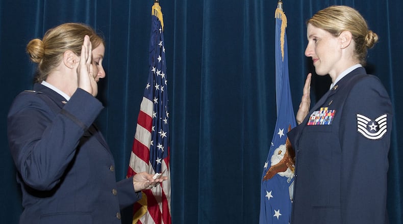 U.S. Air Force Capt. Nicole Tripputi, a contract negotiator with the 645th Aeronautical Systems Group, Big Safari, gives the oath of enlistment to her sister, Tech. Sgt. Jennifer Stem, 88th Aerospace medicine squadron ophthalmic technician, during a re-enlistment ceremony June 19 inside the auditorium of the Wright-Patterson Medical Center at Wright-Patterson Air Force Base. The two have been stationed together at WPAFB for the first time since August 2016. (U.S. Air Force photos/Michelle Gigante)