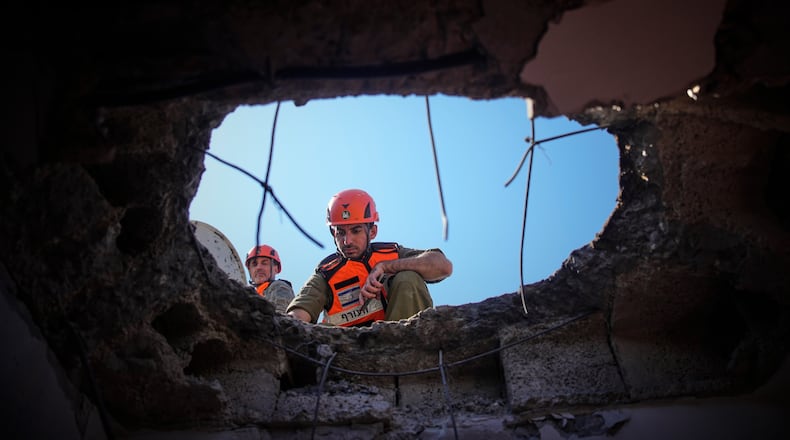 Officers from Israel's Home Front Command inspect a damaged apartment building after an Iranian missile strike in Petah Tikva, Israel, Tuesday, March 3, 2026. (AP Photo/Ohad Zwigenberg)