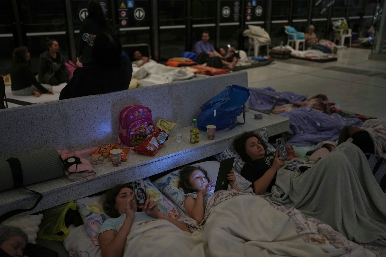 People take shelter in an underground metro station as a precaution against possible Iran missile attacks, in Ramat Gan, near Tel Aviv, Israel, Tuesday, June 17, 2025. (AP Photo/Oded Balilty)