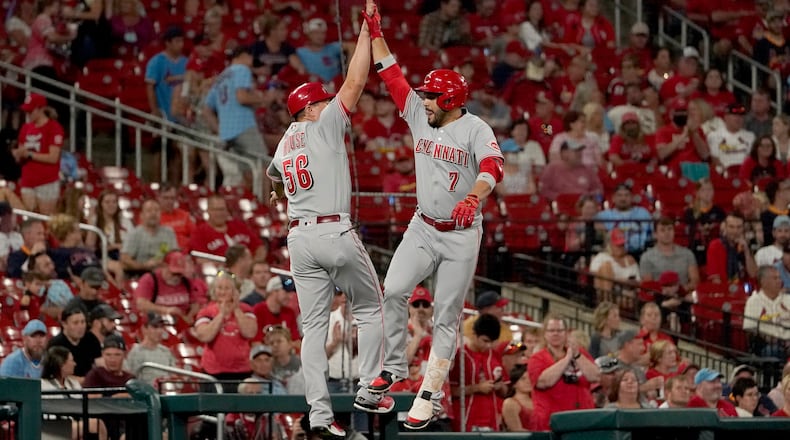 Cincinnati Reds' Eugenio Suarez (7) is congratulated by third base coach J.R. House while rounding the bases after hitting a solo home run during the second inning of a baseball game against the St. Louis Cardinals Friday, Sept. 10, 2021, in St. Louis. (AP Photo/Jeff Roberson)