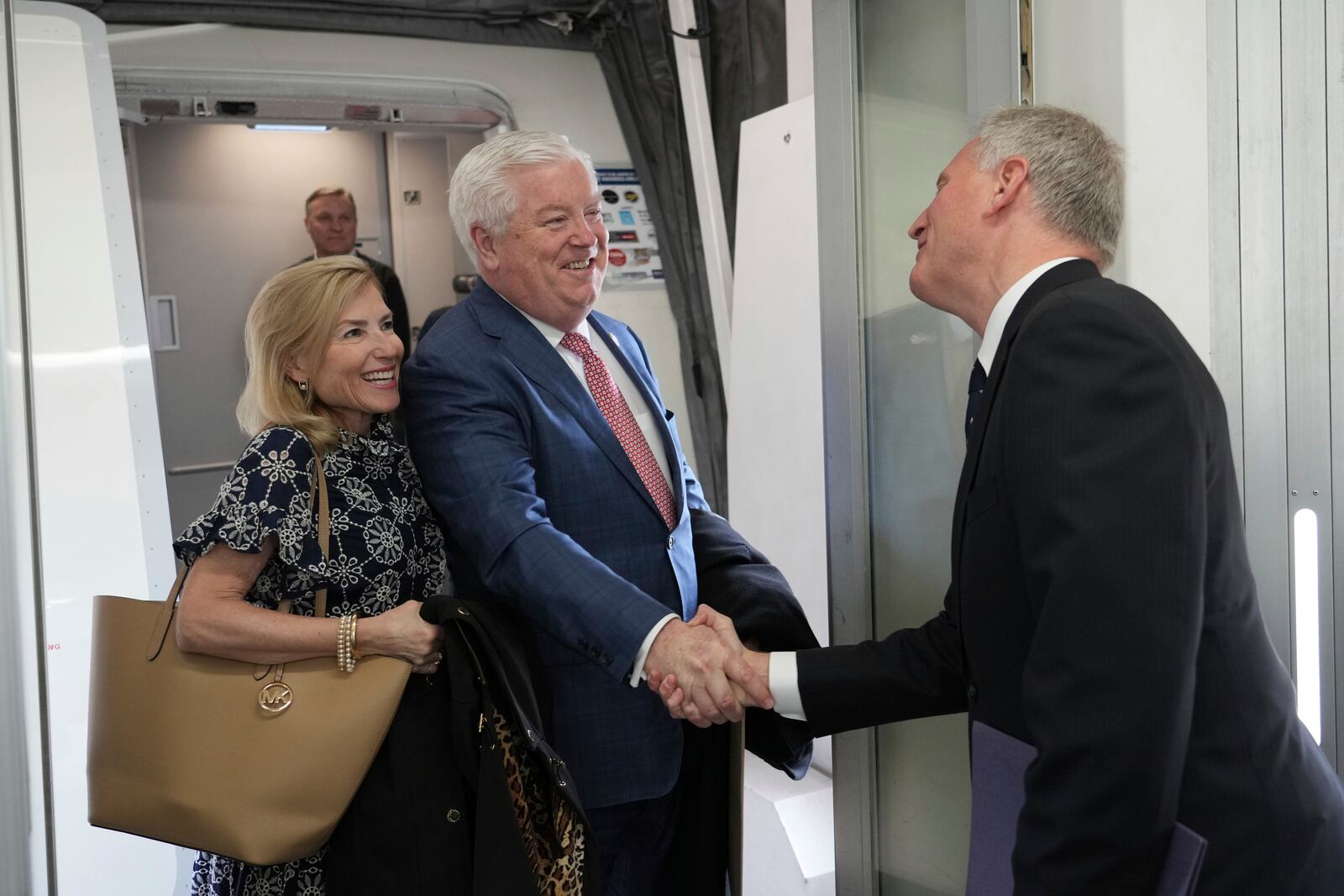 U.S. Ambassador to Japan George Glass, center, and his wife Mary are welcomed by Joseph Young, acting deputy chief of mission at the U.S. Embassy in Tokyo, upon their arrival at Haneda Airport in Tokyo Friday, April 18, 2025. (Kazuhiro Nogi/Pool Photo via AP)