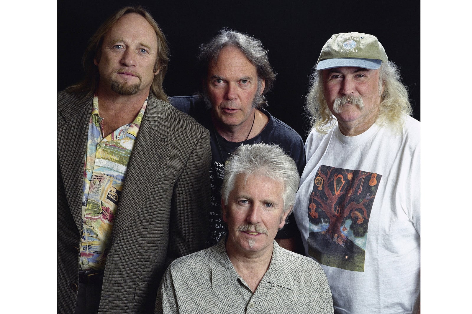 FILE - Musicians Stephen Stills, left, Neil Young, background center, Graham Nash, seated, and David Crosby pose for a photo at the Pierre Hotel, Oct. 13, 1999, in New York. (AP Photo/Jim Cooper, File)