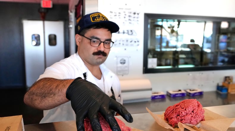 Nate Abeyta, owner and founder of Deep Cuts butcher shop prepares an order of ground meat for a customer, Tuesday, Oct. 21, 2025, in Dallas. (AP Photo/Tony Gutierrez)