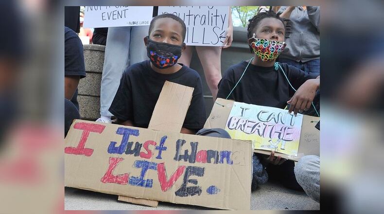 Two young boys take part in a rally for George Floyd Saturday, May 30, in Downtown Dayton. MARSHALL GORBYSTAFF