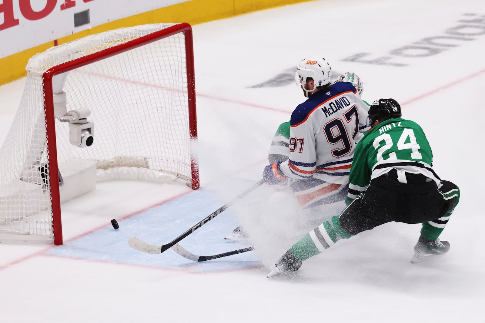 Edmonton Oilers center Connor McDavid (97) scores against Dallas Stars goaltender Casey DeSmith and center Roope Hintz (24) during the second period of Game 5 of the Western Conference finals in the NHL hockey Stanley Cup playoffs, Thursday, May 29, 2025, in Dallas. (AP Photo/Gareth Patterson)