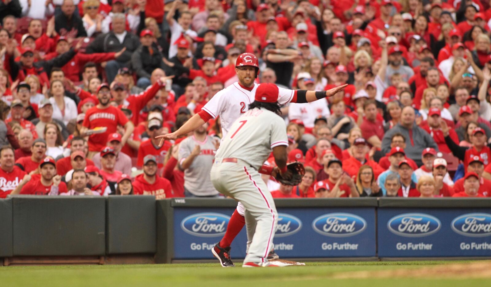 The Reds’ Zack Cozart avoids a tag against Phillies third baseman Maikel Franco on Monday, April 3, 2017, at Great American Ball Park in Cincinnati. David Jablonski/Staff
