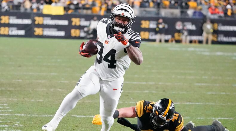 Cincinnati Bengals running back Samaje Perine (34) runs away from Pittsburgh Steelers linebacker Robert Spillane (41) on his way to a touchdown during the first half of an NFL football game, Sunday, Nov. 20, 2022, in Pittsburgh. (AP Photo/Gene J. Puskar)