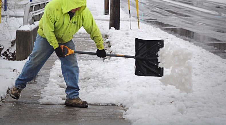 Jarrod Boyd shovels the first heavy snowfall of the season off the sidewalk in front of his home in Fairborn, Sunday, Jan. 31, 2021. MARSHALL GORBY\STAFF
