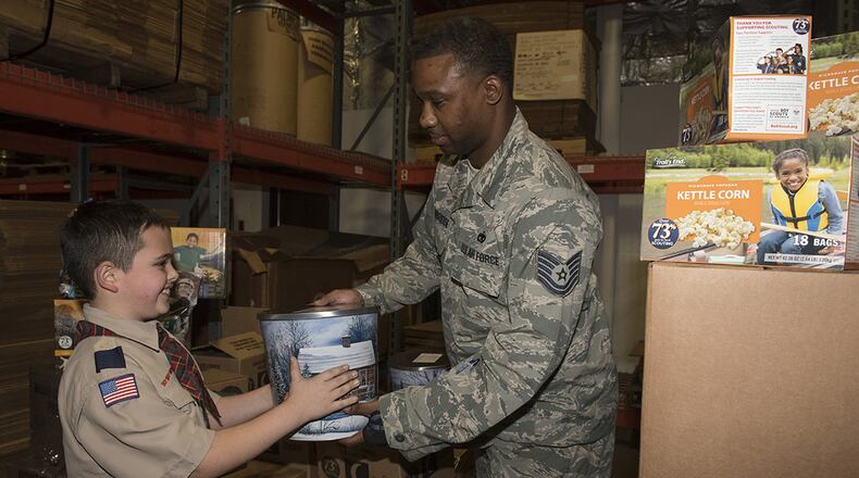 U.S. Air Force Tech Sgt. James Stembridge, 88th Logistics Readiness Squadron transportation management, receives a popcorn canister from Spencer Cabral as part of the Miami Valley Council Boy Scouts of America annual popcorn donation to Airmen Nov. 30. (U.S. Air Force photo/Michelle Gigante)