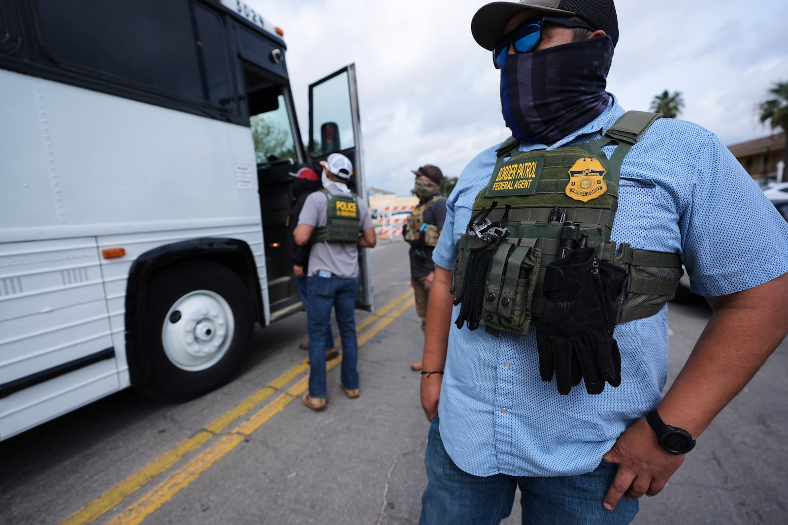 A Border Patrol agent looks on as a family from Colombia is detained and escorted to a bus by federal agents following an appearance at immigration court Monday, July 14, 2025, in San Antonio. (AP Photo/Eric Gay)
