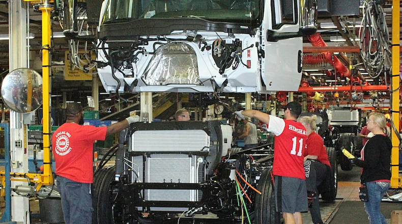 Navistar International employees put together a truck on the assembly line in a 2018 photo. JEFF GUERINI/STAFF