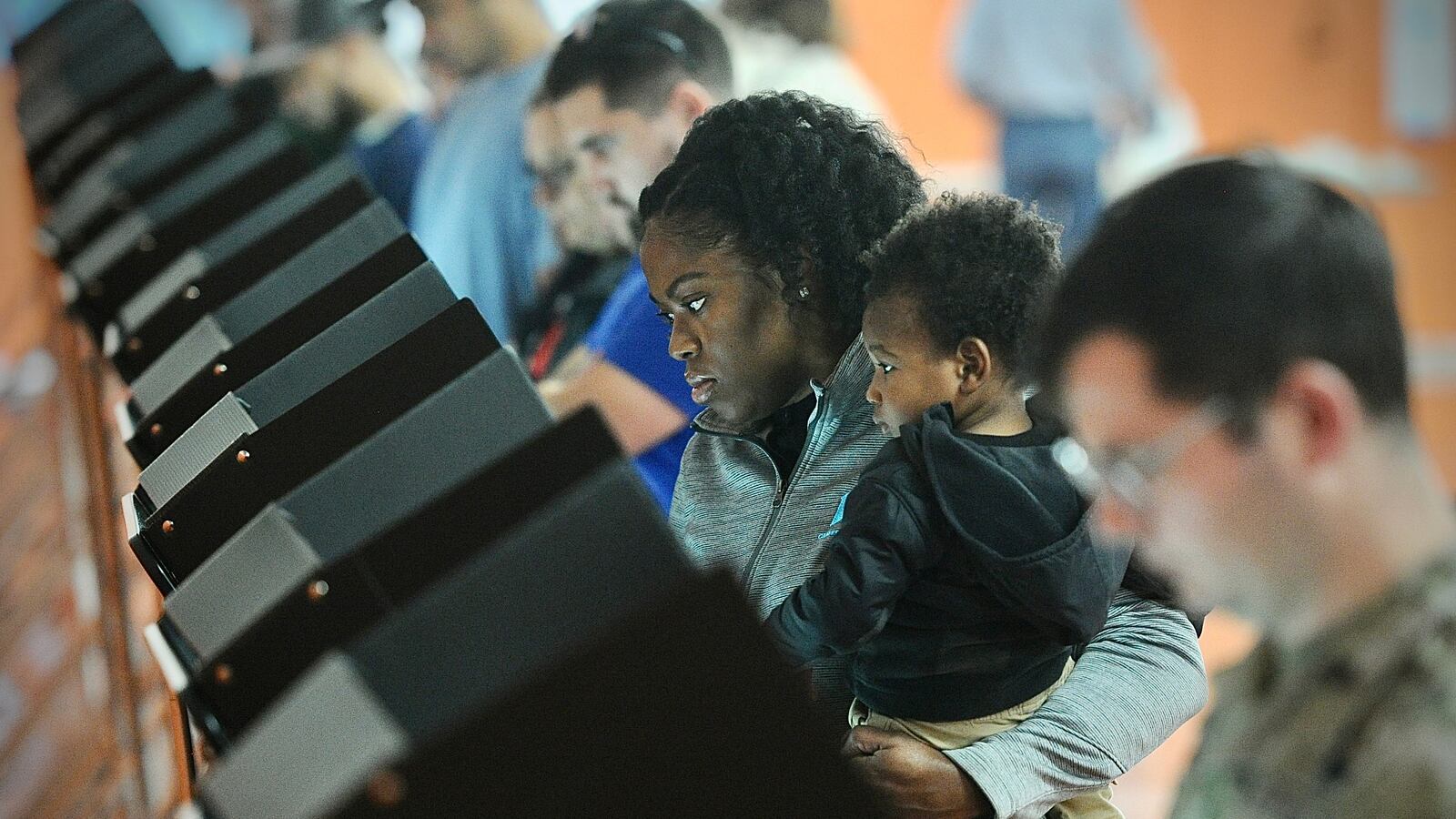 Asia Richardson votes with her 1 year-old son Kash, Tuesday, Nov 7, 2023 at Beavercreek High School. MARSHALL GORBY \STAFF