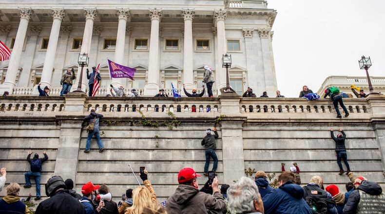 Protestors climb onto the Capitol in Washington on Wednesday, Jan. 6, 2021. A mob of people loyal to President Trump stormed the Capitol on Wednesday, halting Congress’s counting of the electoral votes to confirm President-elect Joe Biden’s victory as the police evacuated lawmakers from the building in a scene of violence, chaos and disruption that shook the core of American democracy. (Jason Andrew/The New York Times)