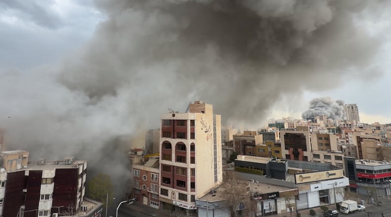 Plumes of smoke from two simultaneous strikes rise over Tehran, Iran, Monday, March 2, 2026. (AP Photo/Mohsen Ganji)