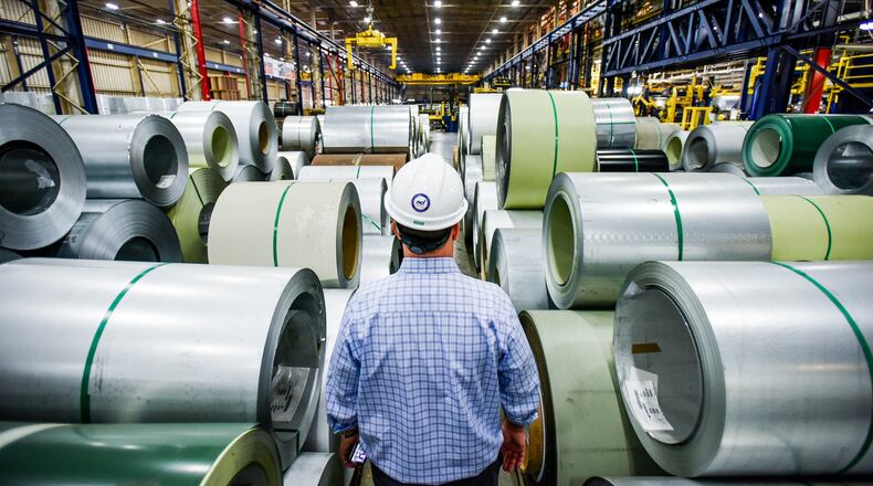 In this 2016 file photo, John Wallace, Vice President of Quality and Technical Systems at NCI Group Inc., walks between coils of steel that are lined up and ready to be coated at Metal Coaters in Middletown. NICK GRAHAM/STAFF 2016