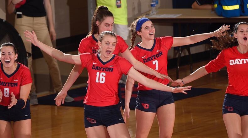 Dayton volleyball players celebrate a point in a match against Ohio on Aug. 29, 2017, at the Frericks Center. Photo by Erik Schelkun