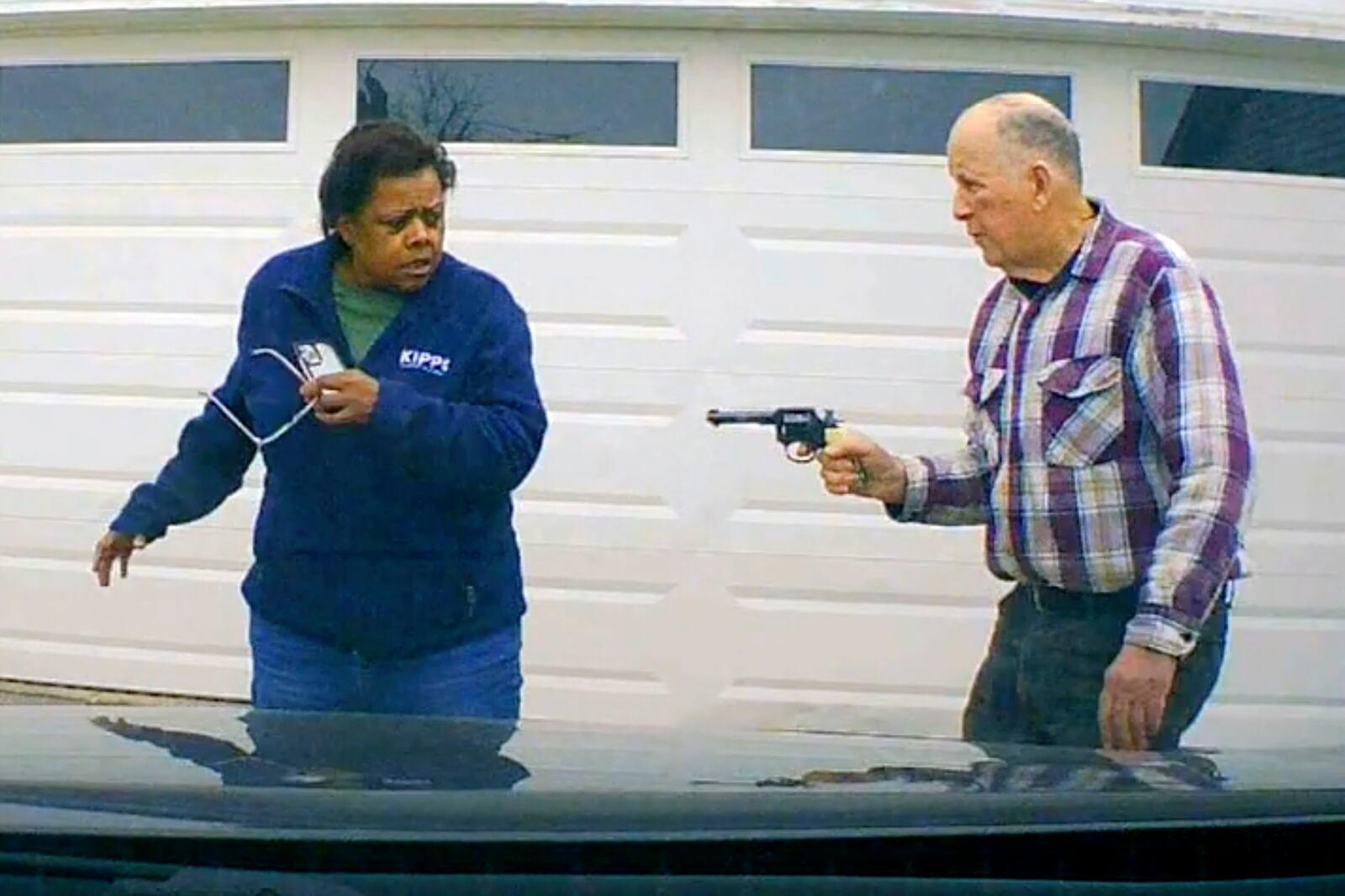 In this image taken from Uber dashcam video released by the Clark County, Ohio, Sheriff's Office, William Brock, right, holds a weapon to Uber driver Lo-Letha Hall outside his home in South Charleston, Ohio, on March 25, 2024. Brock, 81, who authorities say fatally shot Hall who he thought was trying to rob him after scam phone calls deceived them both, was indicted on a murder charge, Monday, April 15, 2024, by a Clark County grand jury. Hall had no knowledge of the calls made to Brock, authorities said. (Clark County Sheriff's Office via AP)