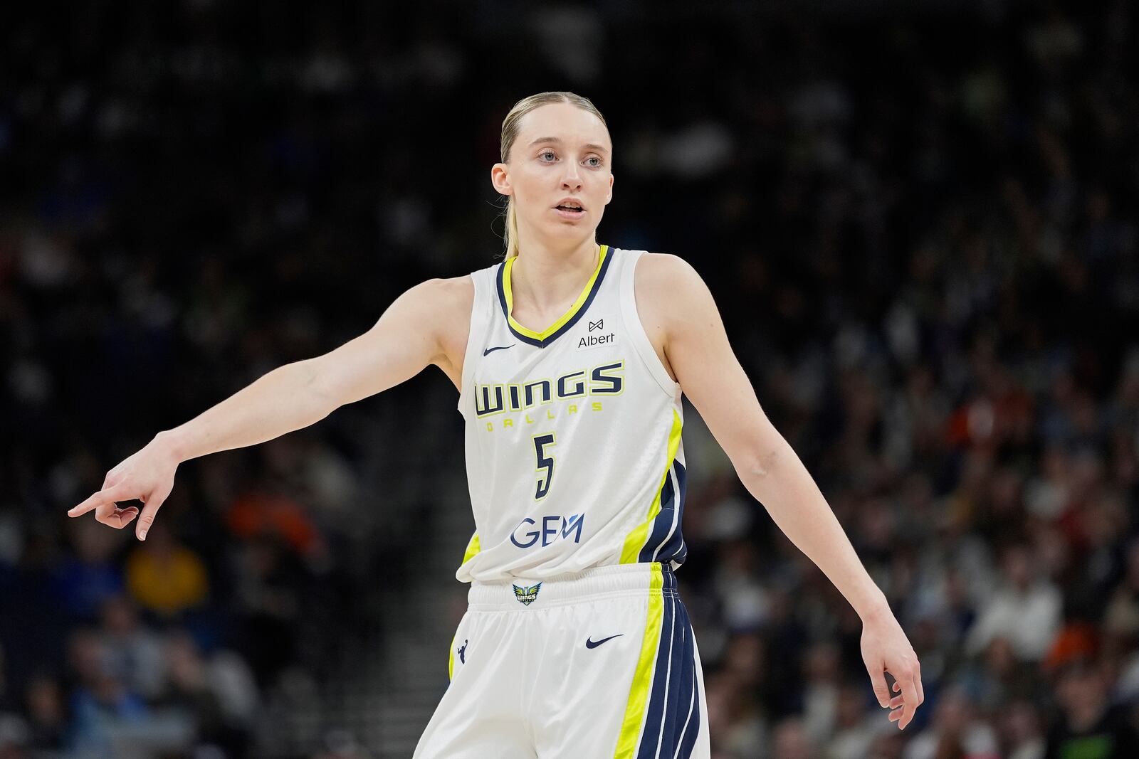 Dallas Wings guard Paige Bueckers (5) points during the first half of a WNBA basketball game against the Minnesota Lynx, Wednesday, May 21, 2025, in Minneapolis. (AP Photo/Abbie Parr)