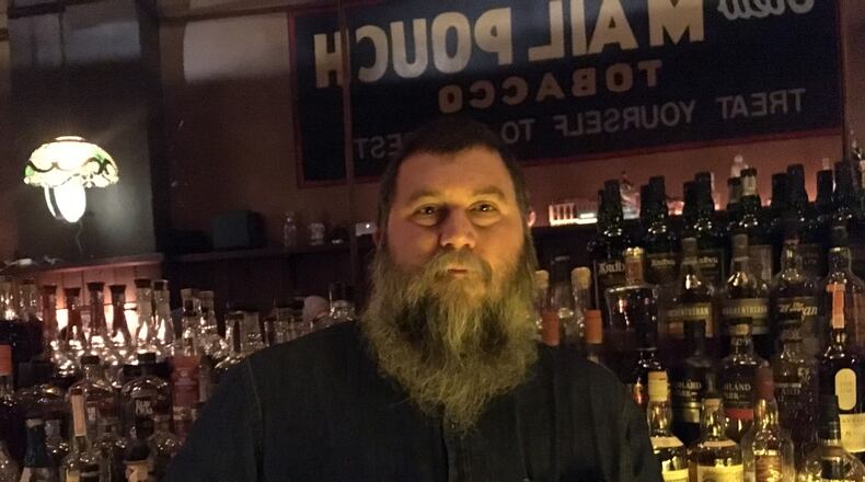 Joseph "Joe" Head holds a bottle of Knob Creek.  Head just celebrated his 20th anniversary at The Century Bar.
