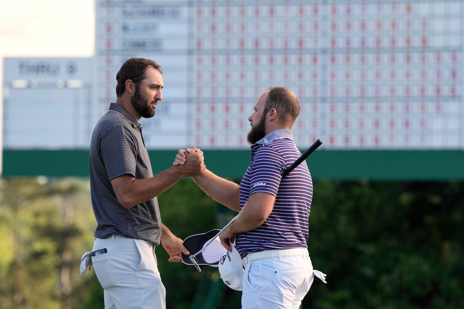 Scottie Scheffler Tyrrell Hatton, of England, shake hands after the third round at the Masters golf tournament, Saturday, April 12, 2025, in Augusta, Ga. (AP Photo/David J. Phillip)