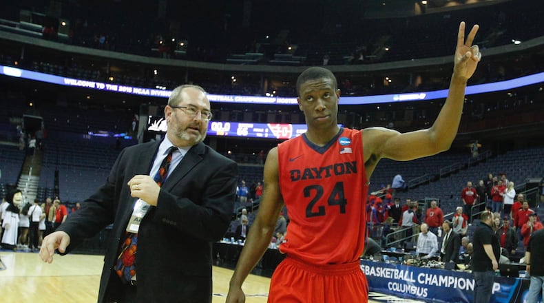 Dayton's Jordan Sibert, right, and Doug Hauschild, UD's director of media relations, leave the court after a victory against Providence in the second round of the NCAA tournament on Friday, March 20, 2015, at Nationwide Arena in Columbus. David Jablonski/Staff